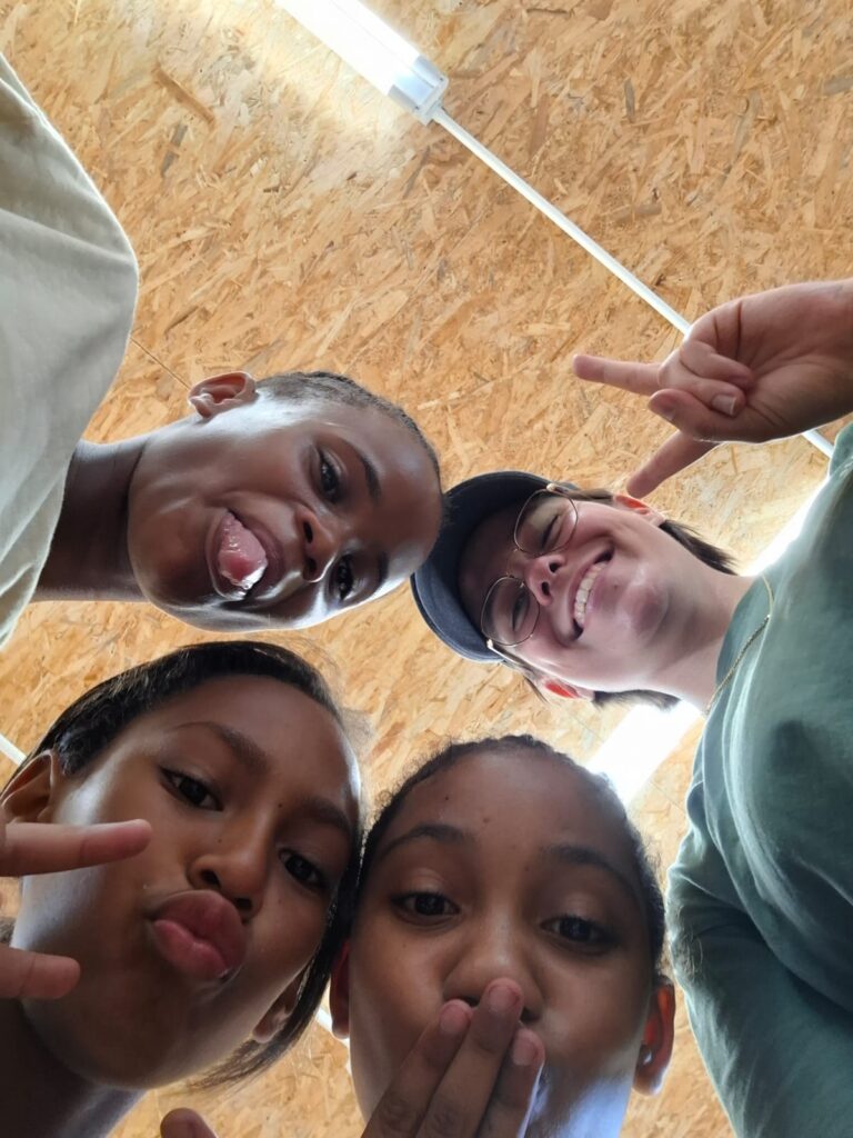 A youth participant and an intern taking a selfie with two girls at the centre