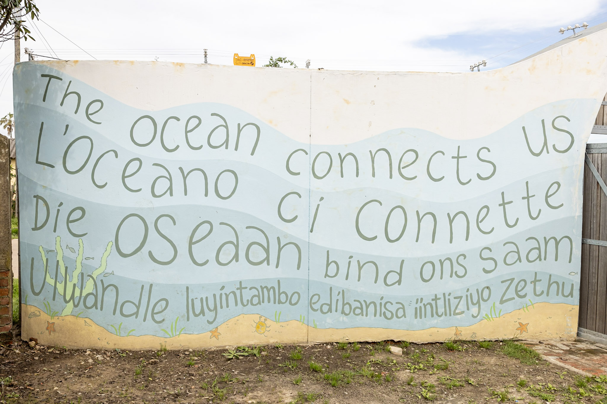 Mural reading “The ocean connects us” in English, Italian, Afrikaans and isiXhosa