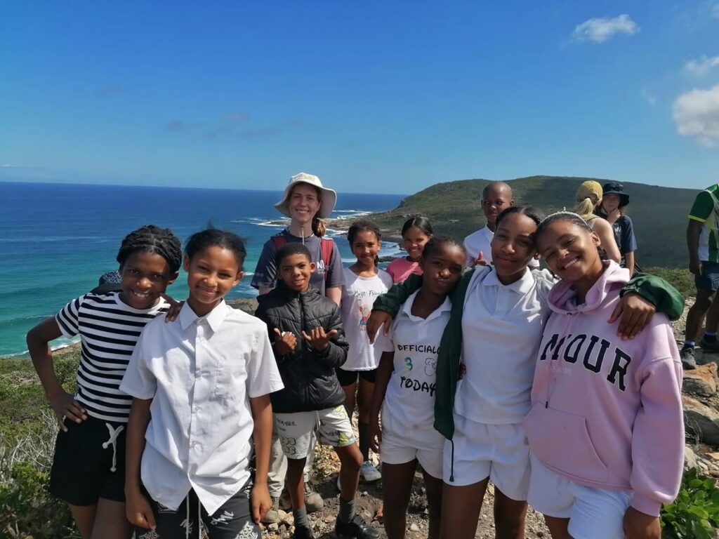Young people smiling together on a clifftop above the sea